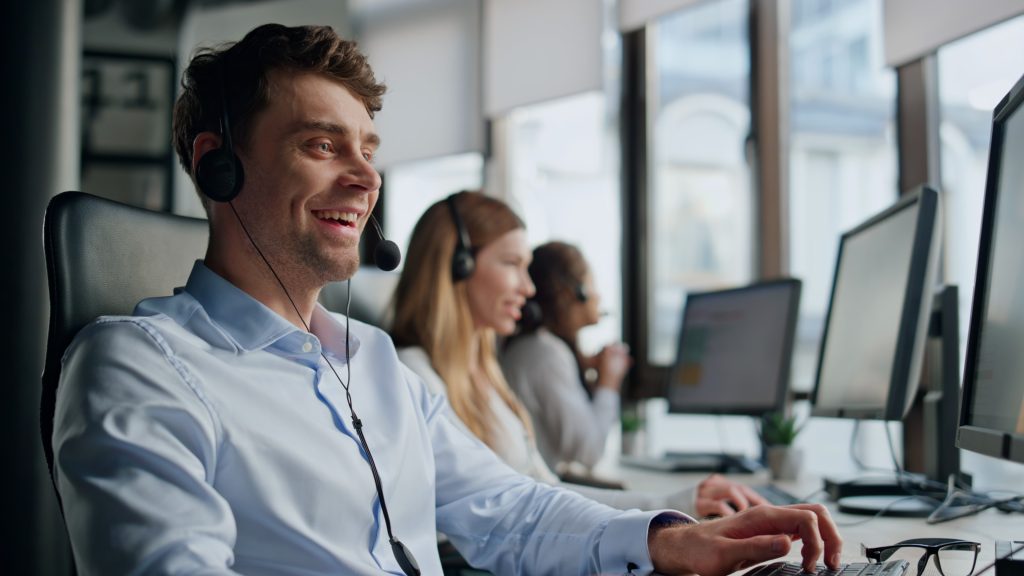 A friendly customer service interaction, with an agent smiling and talking with a customer. This illustrates the value of the 5 free ways to improve customer experience in 2025.