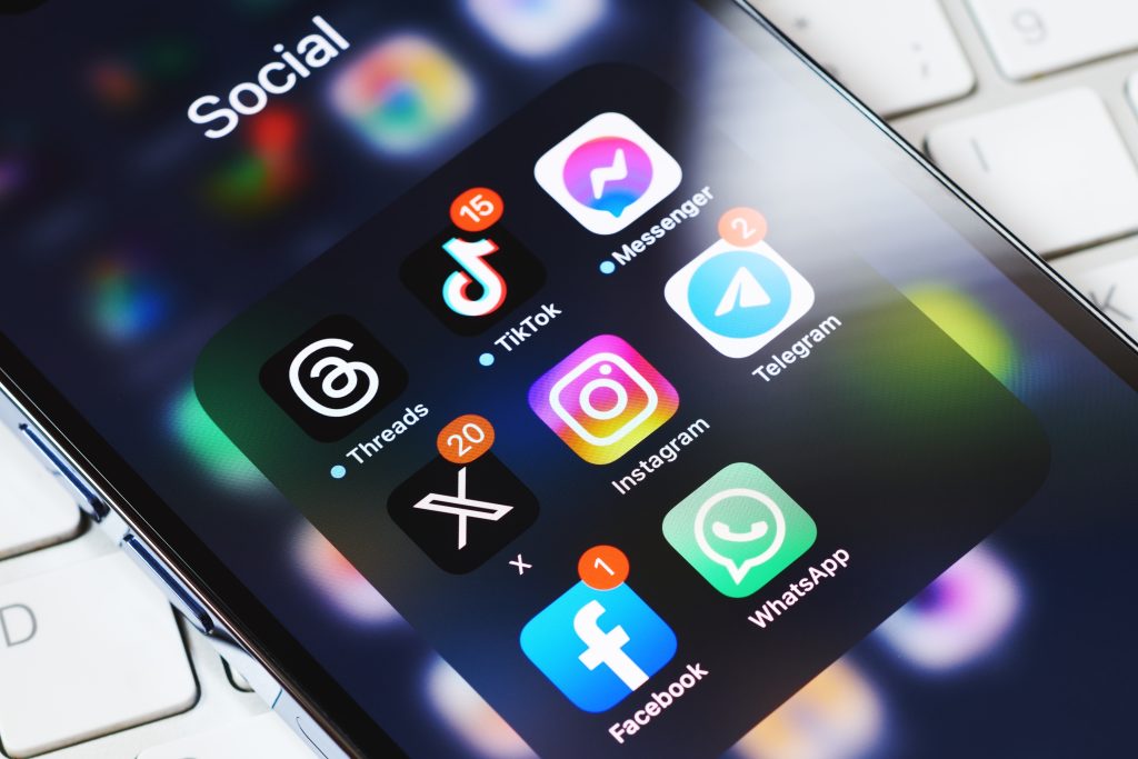 A smartphone with social media icons illustrates the channels customers use today, and why you need to leverage social media for customer support