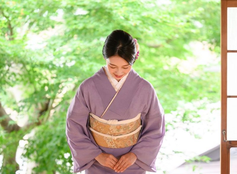 A Japanese women bows to illustrate Omotenashi and the hospitality in customer service