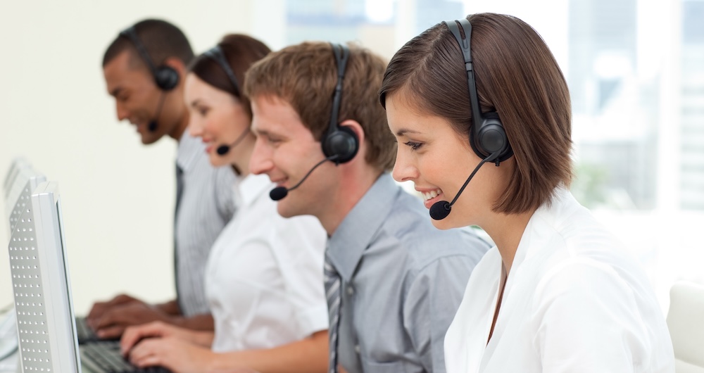 A friendly customer service team working on computers in a modern contact center, using a cloud contact center solution and not being held back by myths.